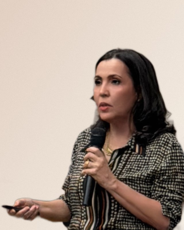 Tatiana Teixeira falando ao microfone durante uma palestra
